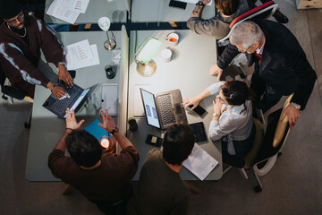Top view of multigenerational colleagues discussing strategies at a business meeting, showcasing...
