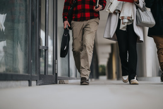 Partial view of two professional business partners walking together outdoors, highlighting teamwork and collaboration.