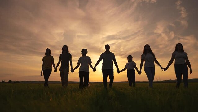 community big family in the park. large group of lifestyle sunset people holding hands walking silhouette nature in the park. big family childhood dream concept. people in the park. big family
