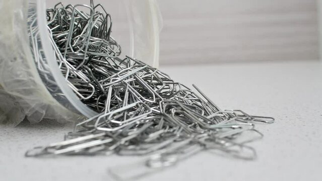 Paper clips intertwined in chaos on a bright surface, a visual representation of disordered creativity.