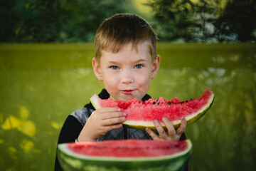 A little boy eats a watermelon. - 767543331