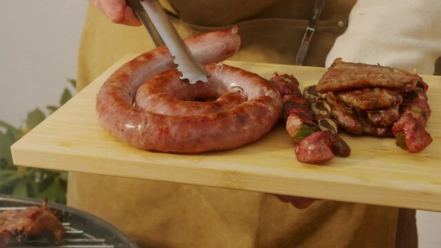 Traditional spanish barbeque, big sausage chorizo botifarra, pork and beef ribs on grill with fire, american style cooking, chef grilling meat fat food, steaks and sausages on bbq.
