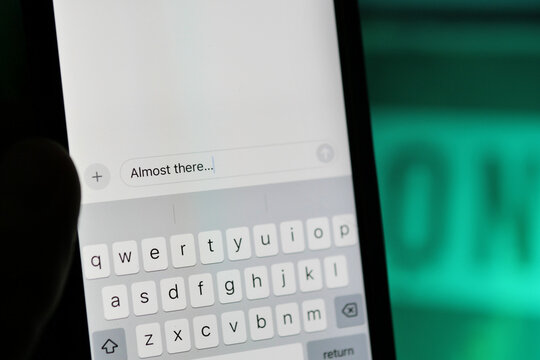 Person writing an "Almost There" text message in a smartphone messenger