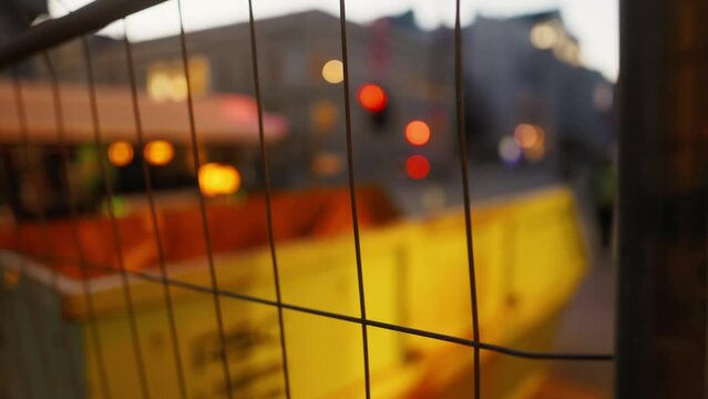 Blurry construction site view through ambertinted wire fencing mesh