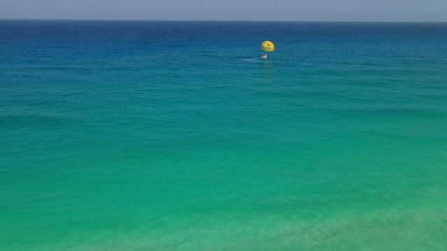 Landing of a parachute in the middle of the beautiful sea of ​​clear waters.