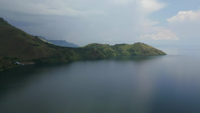Aerial flight over Lake Danau Toba on a cloudy day at Tongging, Berastagi, North Sumatera, Indonesia.