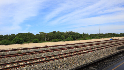 Close-up view of multi-track railroad tracks stretching into the distance against a blue sky background