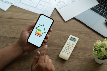 Energy Efficient House man use house icon with energy efficiency scale Invoice And Economy - obrazy, fototapety, plakaty