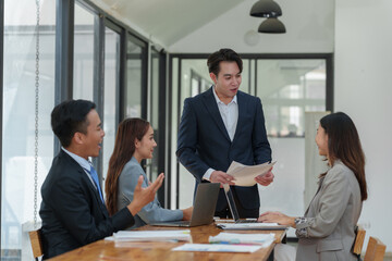 Group of business people meeting about business plans Presenting and explaining financial charts of partners from papers, graphs and data on laptop computer at office.