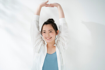 Naklejka premium 背伸びする20代女性ナチュラルイメージ
