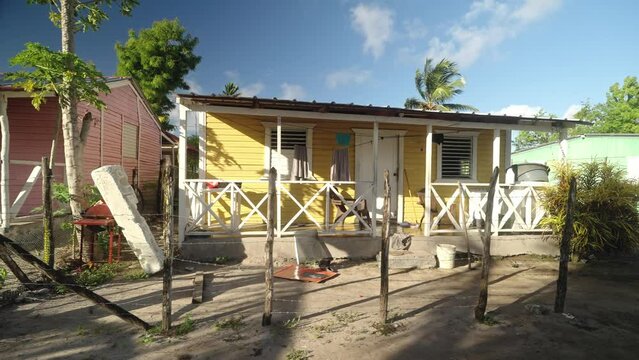 Profile view of a small yellow hut in the Caribbean during afternoon.