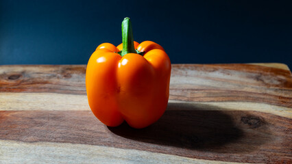 A photograph capturing ripe, fresh orange peppers arranged on a wooden surface.