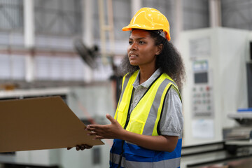 African American engineer or businesswoman checking Kraft paper stock in warehouse	 - 767563706