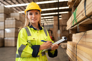 Portrait Caucasian business woman checking wood stock with clipboard at timber wood warehouse	 - 767563759