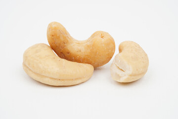 Closeup of three tasty cashew nuts isolated background