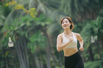 asian woman jogger running in green nature public park.