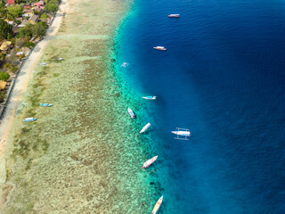 Aerial view of tourist boats over the coral reef flat on a small tropical island