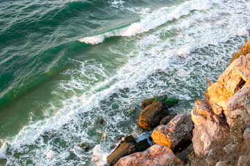 stormy sea with waves hitting the rocky shore, view from above. Seascape