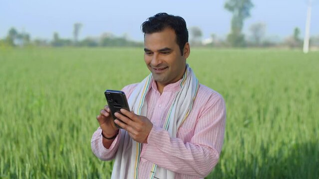 Desi young Indian farmer using smartphone on field - modern agriculture  technology usage in rural area  slaves of technology. Mature village man surfing internet in leisure time - village network ...