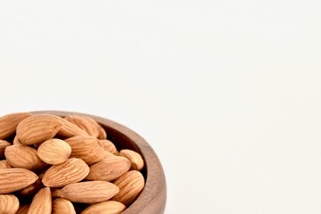 木の皿に盛った生のアーモンドのアップ