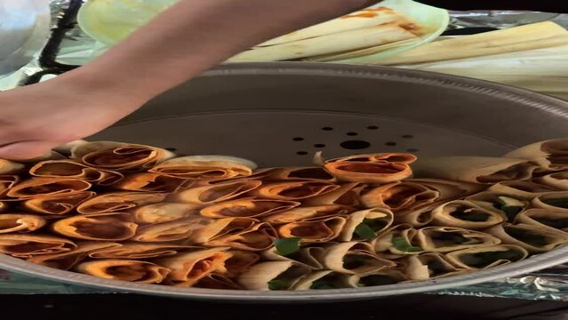 mujer mexicana haciendo tamales con harina de maiz, comida tipica mexicana