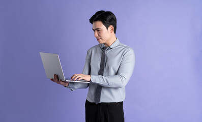 Portrait of Asian male businessman posing on purple background