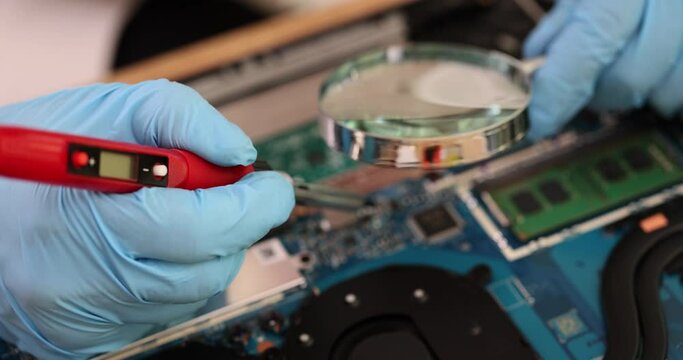 Person in gloves solders details in computer with soldering iron