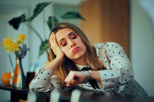 Sad Woman Waiting at a Counter Looking at her Watch. Annoyed customer waiting for client service for too long 
