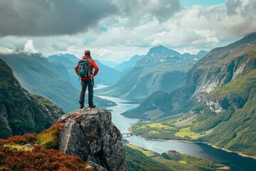 Tourist standing on a mountain peak, arms outstretched feeling Impressed, encompassed by vast rugged terrain and valleys, a celebration of exploration and natural beauty.