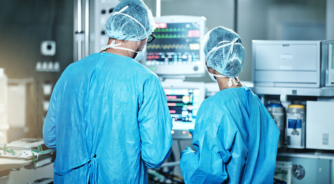 Surgery, back or surgeons with teamwork for emergency, accident or healthcare in hospital clinic. Heart rate monitor, medical or doctors in surgical collaboration in operating room to support or help