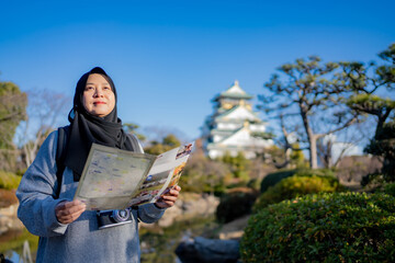 Travel, Muslim travel, Asian Muslim female tourist walking and visitor learning about history at...