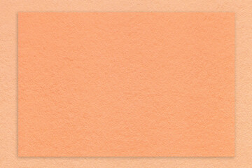 Texture of craft peach fuzz paper background with coral border, macro. Vintage kraft cardboard
