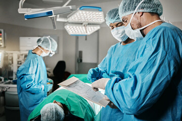 Healthcare, surgery and doctors with patient, chart and advice in theater for medical emergency....