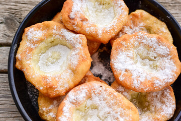 Traditional Bulgarian home made deep fried  patties  covered with sugar  оn rustic backgroud.Mekitsa or Mekica,  on wooden  rustic  background. Made of kneaded dough that is deep fried 