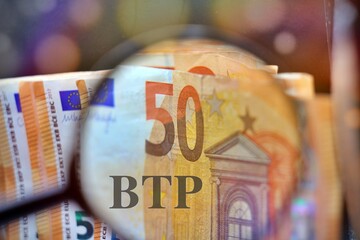 Magnifying glass over the pile of money with the text “BTP” translating as Italian government...