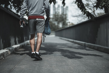 A man walking on footbridge in the city center park before cardio workout.  Health and Lifestyle in...