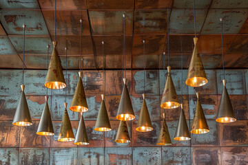 A vintage-inspired ceiling with distressed copper tiles, accented by a cluster of stylish metallic hanging cone lamps in varying shades of bronze and gold, casting a warm, inviting glow. - Powered by Adobe