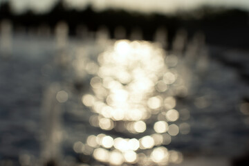 Fountain is a blurred background of water. The glare in the sun is in motion. Abstract natural...