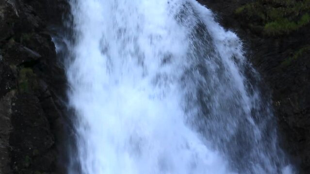 Close-up with vertical panoramic camera movement from top to bottom of the waterfall. Saut deth Pish in the Aran Valley (Catalan Pyrenees)
