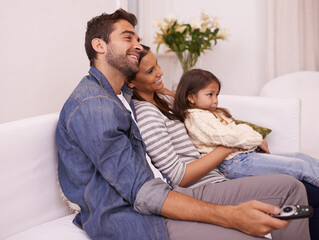 Family, remote control or fun to relax on sofa, watching tv or cartoon as bonding together in home. Papa, mama or girl child on couch to enjoy show, series or broadcast in living room at weekend