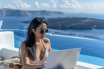 Beautiful asian woman working on laptop computer in luxury hotel on Santorini island, Greece
 - obrazy, fototapety, plakaty
