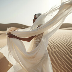 Fototapeta na wymiar Woman in a long white dress walking in the desert with flowing fabric in the wind 