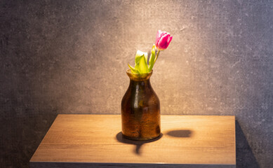 Flower in a vase on a night table in hotel room - 767667524