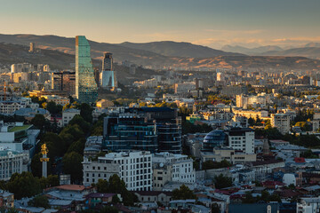 View of Tbilisi from the surrounding hills. In the background you can see the Caucasus Mountains. A warm autumn day in the capital of Georgia. - 767667525