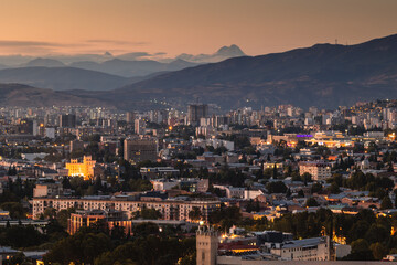 View of Tbilisi from the surrounding hills. In the background you can see the Caucasus Mountains. A warm autumn day in the capital of Georgia. - 767667594