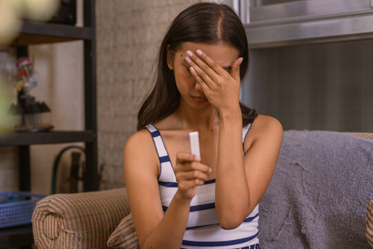 A disheartened young woman dealing with the stress of a negative pregnancy test, reflecting on fertility and conception challenges.