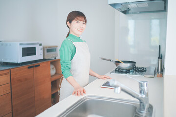 キッチンカウンターでタブレットを使ってレシピを考える女性