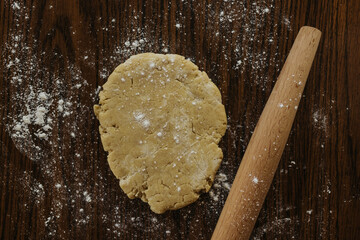 Rollling out sourdough on kitchen table with wooden rolling pin