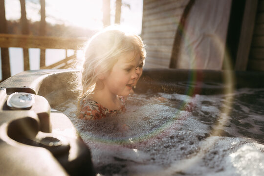 Kids in bubbly hot tub outdoors during vacation