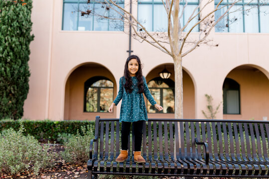 Six Year Old Girl Standing on Bench in Park in San Diego